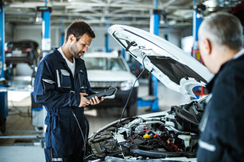 mechanic checking automative software in garage