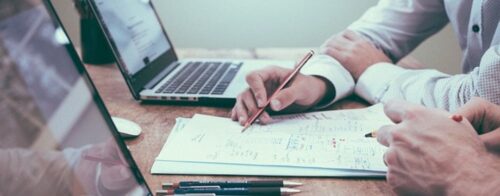 shot of a laptop and note taking