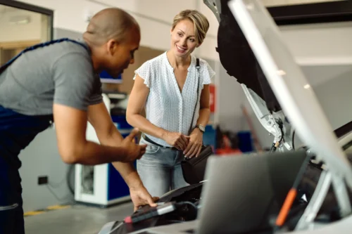 happy-woman-talking-her-car-mechanic-repair-shop_converted